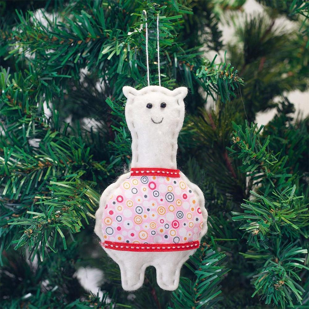 White llama ornament with a colorful skirt hanging on a Christmas tree.