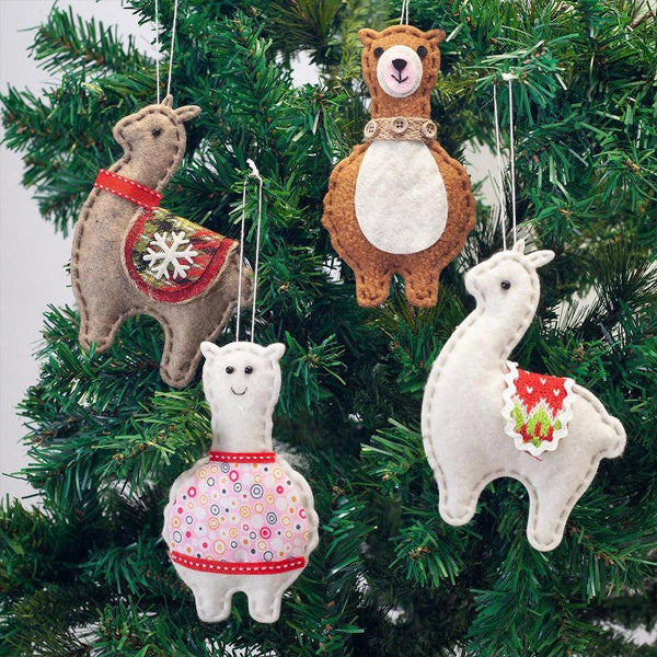Four festive ornaments shaped like animals hanging on a Christmas tree.