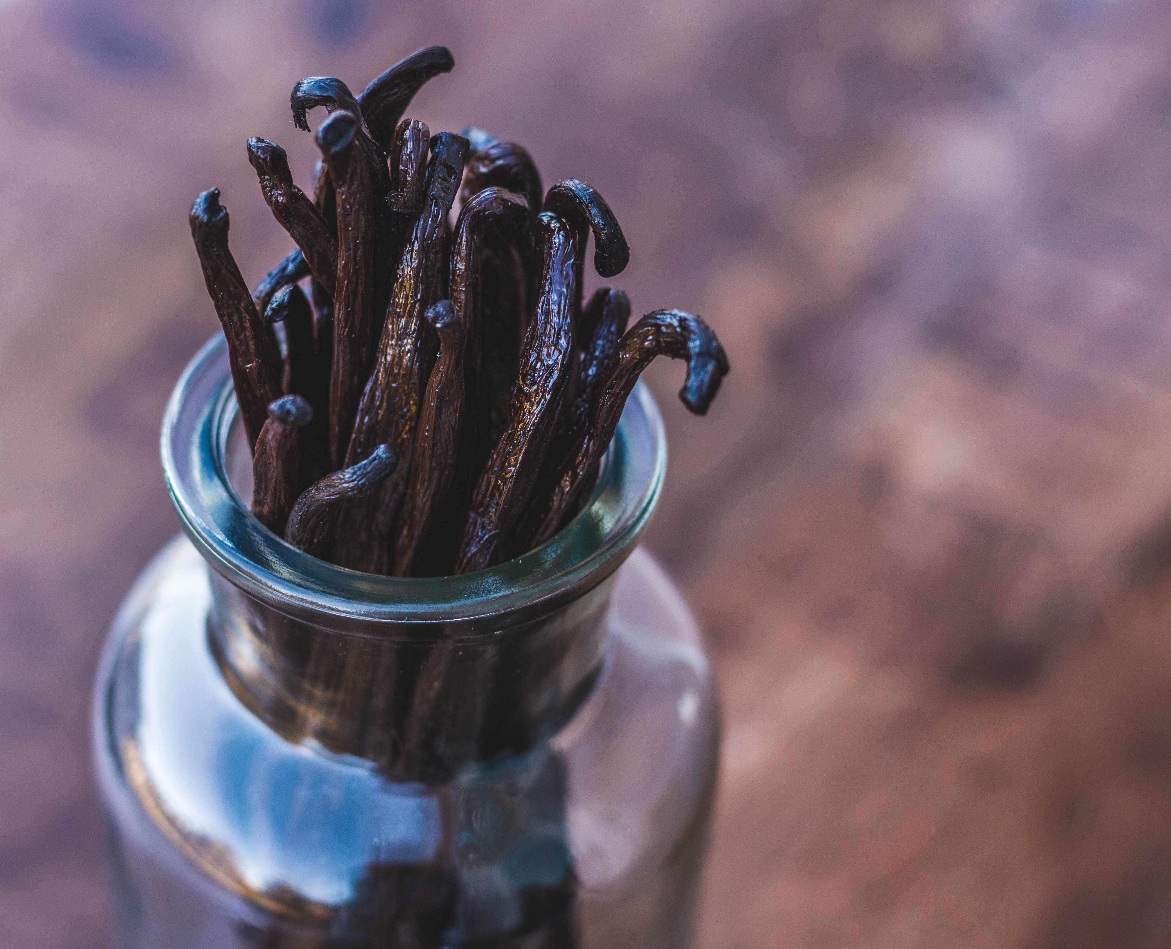 Vanilla beans in a glass jar with a blurred background
