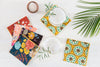 Floral cocktail napkins displayed with a rosemary cocktail, palm frond and salt cellar on a table