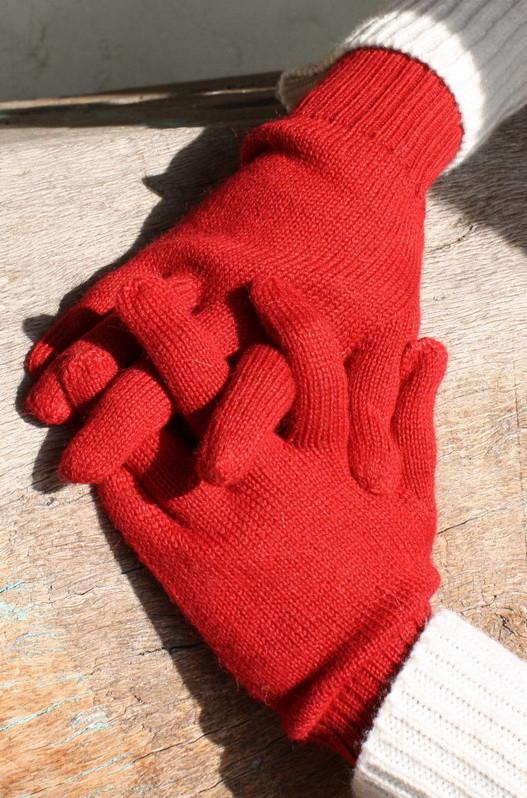 Red knitted gloves on a wooden surface