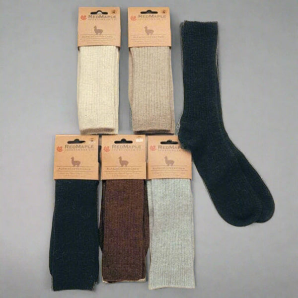 Set of six pairs of socks with packaging on a beige background. Experience the benefits of our Copper Crew Alpaca Socks. Made with undyed alpaca and organic cotton, these socks feature heat-reflecting copper fibers. Machine washable and incredibly soft for daily comfort.