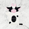 Cow-shaped plush toy on a marble background