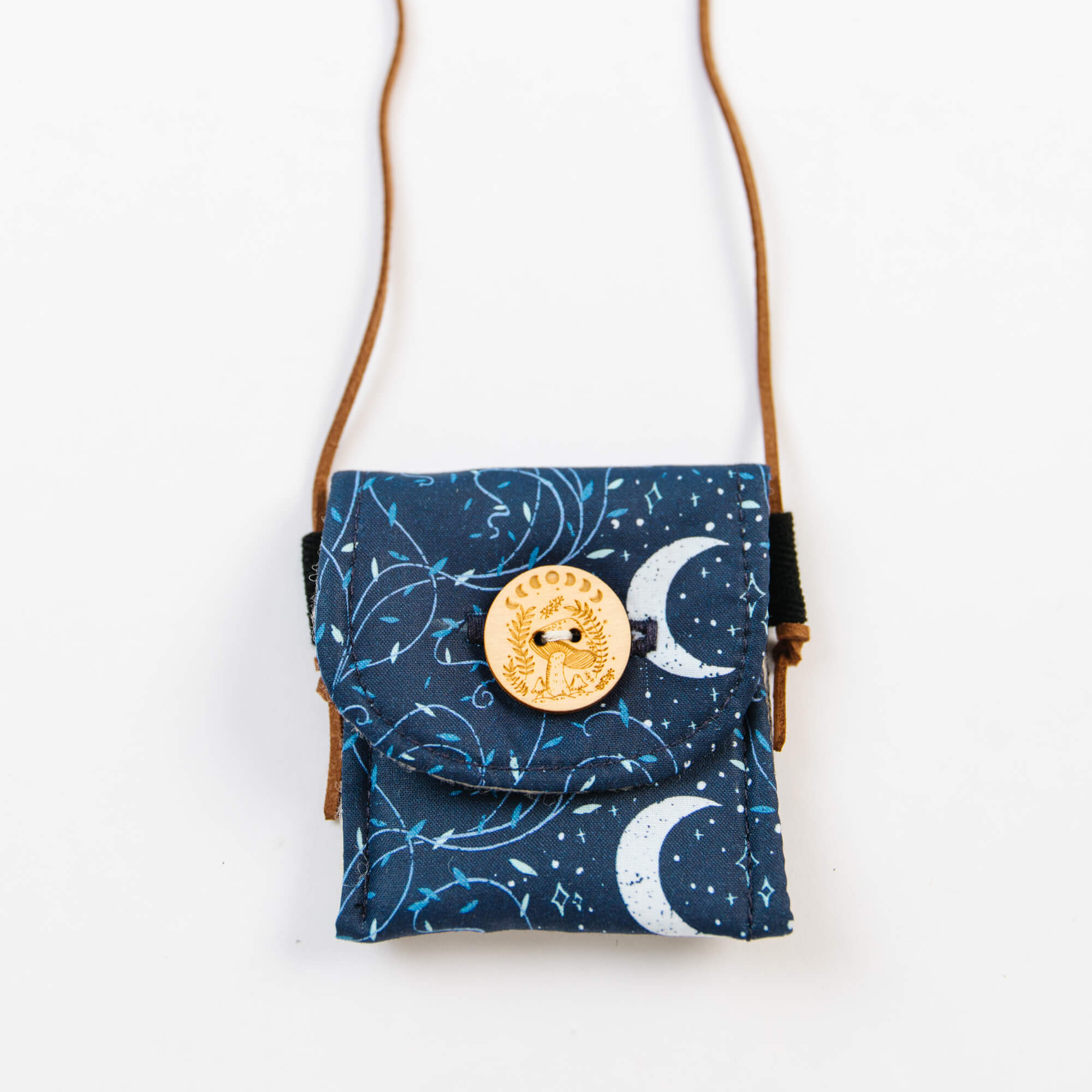 Small crossbody bag with celestial pattern and button detail on a white background