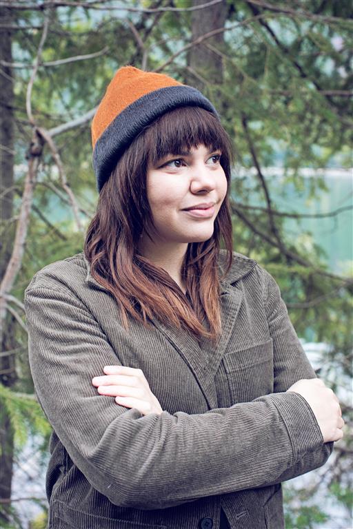 Person wearing a beanie and coat with a natural background