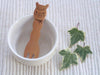 Close-up of alpaca design detail on a small natural wood snack fork for kids