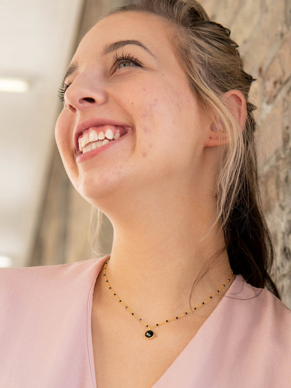 Dainty black and gold beaded necklace by Fair Anita, close-up detail of beads on gold chain