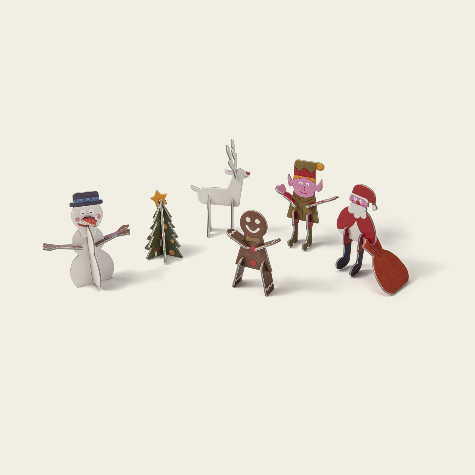 Set of Christmas-themed figurines including a snowman, reindeer, and elves on a beige background