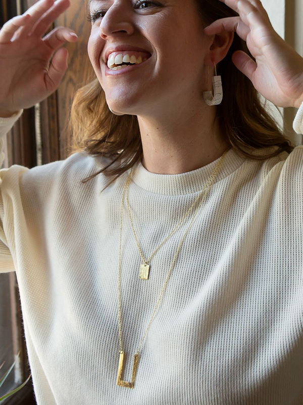 Delicate brass geometric double strand necklace worn as a layered set by Fair Anita