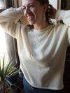 Close-up of delicate brass geometric necklace charms from Fair Anita India Collection