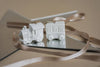 White ceramic train set on a reflective surface with a beige background