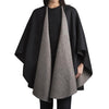 Two-tone black and gray cape worn by a person on a white background