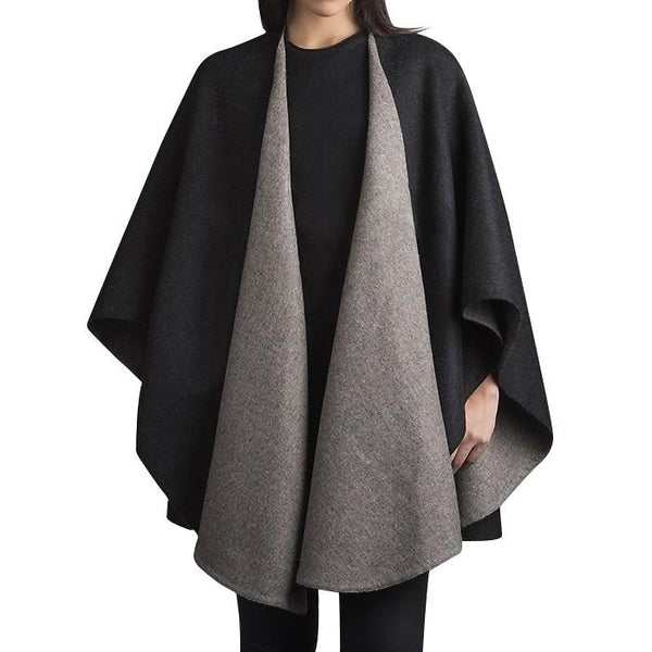 Two-tone black and gray cape worn by a person on a white background