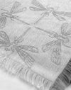 Textile with embroidered dragonfly patterns on a light gray background