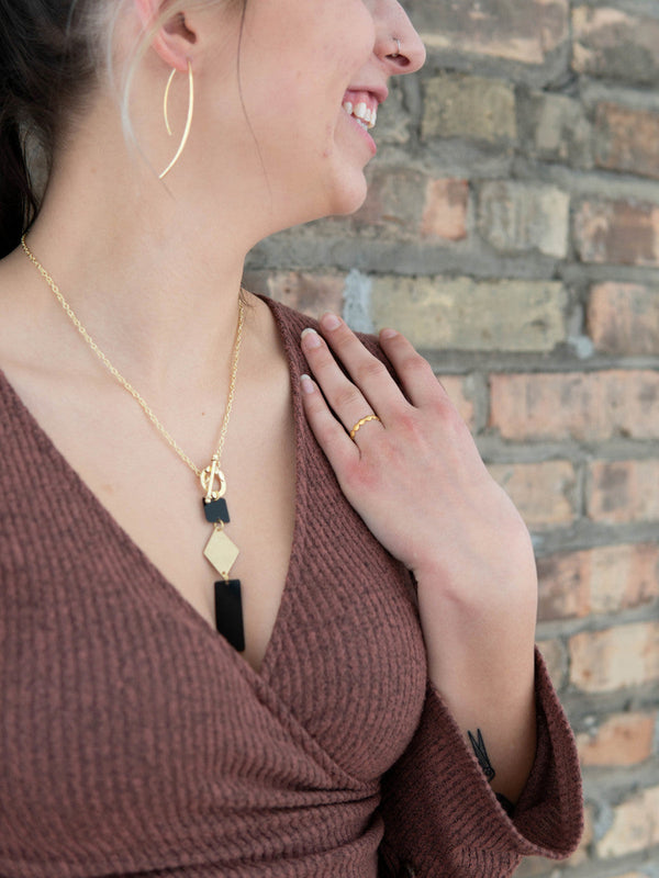 Close-up of the slate and gold dangle necklace pendant by Fair Anita showing geometric design detail