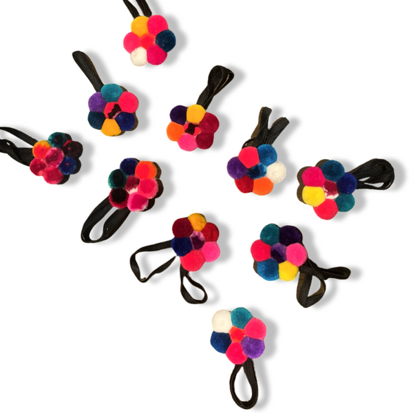 Colorful flower-shaped hair ties on a white background