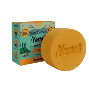 Nanah curly hair shampoo bar with vanilla scent next to its eco-friendly packaging on a white background