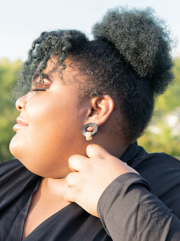 Close-up of natural horn earrings showing earthy tones and organic texture