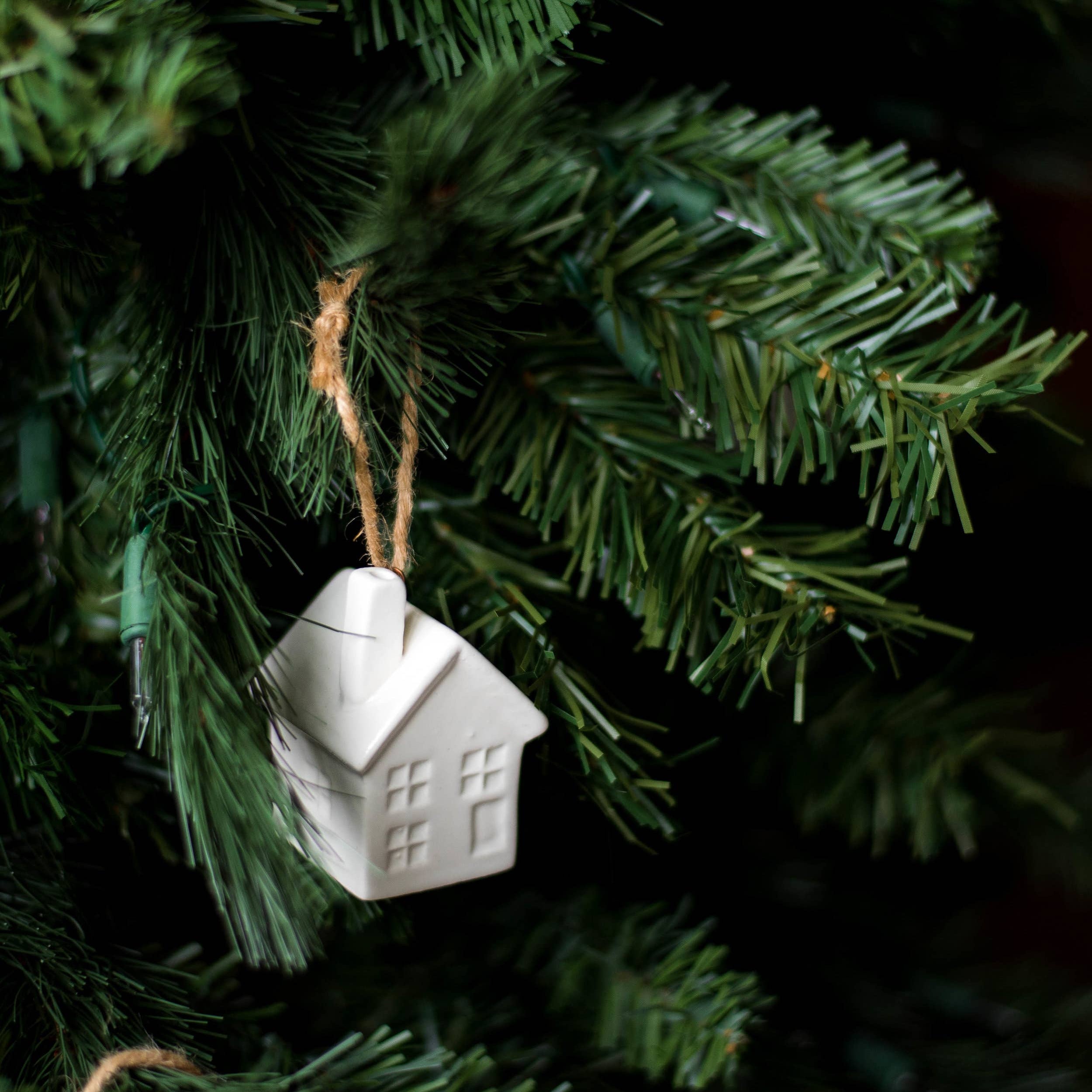 White porcelain hot air balloon ornament with natural jute loop hanging on Christmas tree
