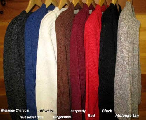 Row of sweaters in various colors on a wooden rack.