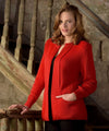 Woman wearing a red cardigan standing on a staircase.