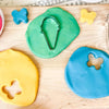 Colorful play dough with cookie cutters on a wooden surface