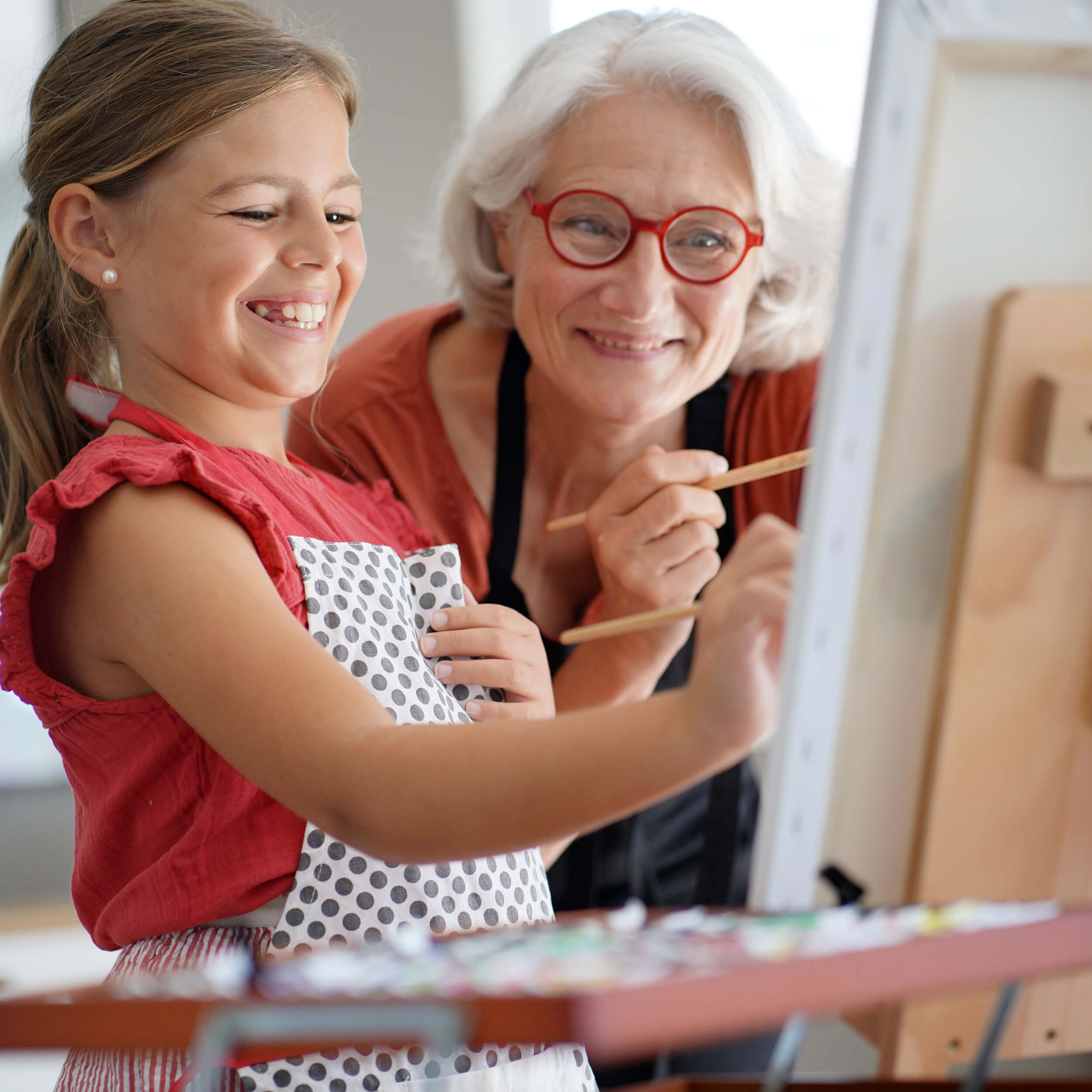 Grandmother and granddaughter painting together