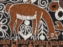 Close-up of a textured fabric with a bear design and intricate patterns.