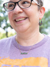 Close-up of enameled Justice word necklace by Fair Anita handcrafted in India
