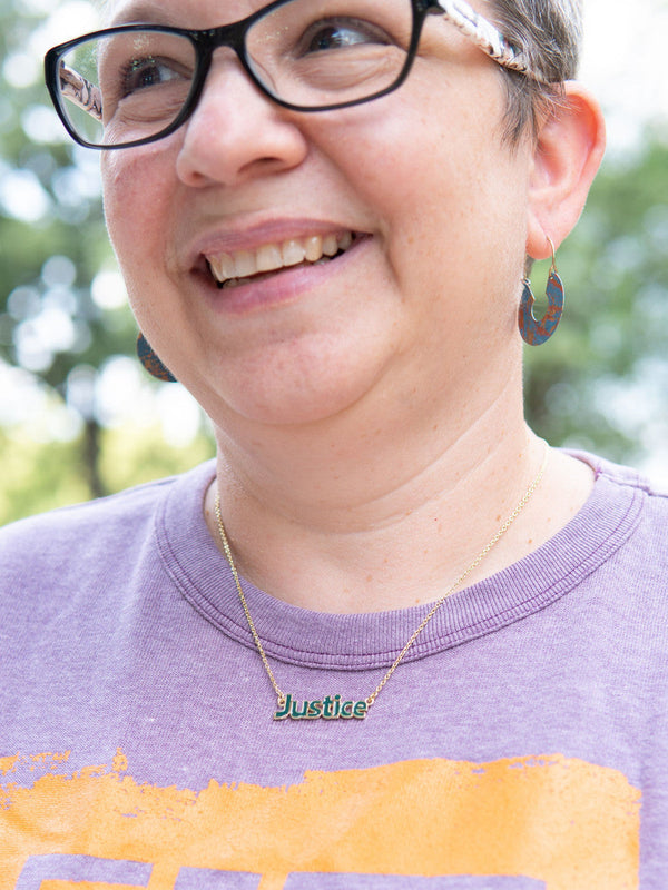 Close-up of enameled Justice word necklace by Fair Anita handcrafted in India
