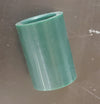 Green rubber grommet on a dark metallic surface