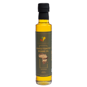 Bottle of 100% Pure Lightly Toasted Sesame Oil by Nature's Essentials with black cap and sesame seed label, made from ethically sourced Ghanaian sesame seeds