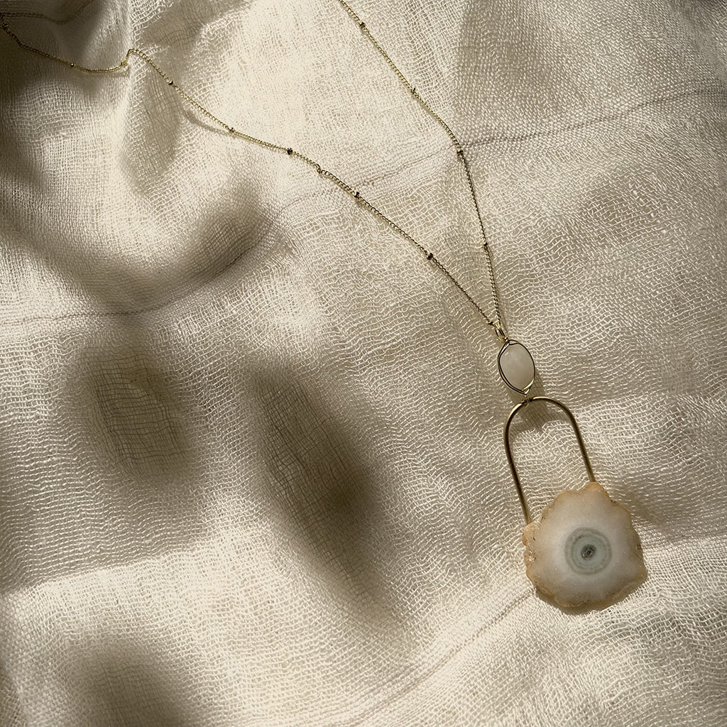 Discover the transformative power of our Solar Quartz Eye Necklace. Handmade with love in India, this unique piece features a polished solar quartz stone and a delicate moonstone. Believed to attract emotional power and enhance energy, it's the perfect accessory for those seeking beauty and spiritual connection. Shop now and experience the magic of this handcrafted masterpiece.