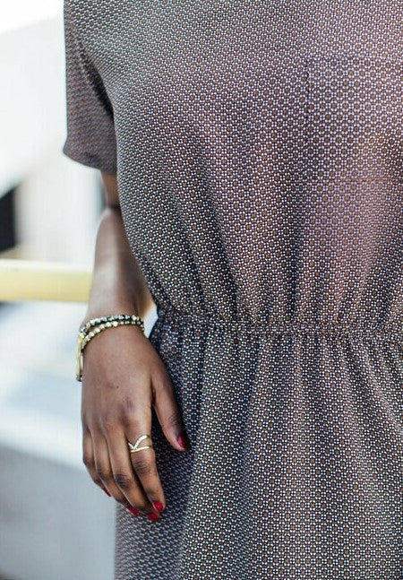 Woman wearing dark elastic charm bracelets stacked on wrist, Fair Anita fair trade jewellery