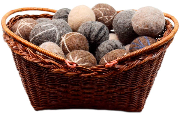 Wicker basket filled with brown and gray stone balls on a white background