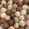 Collection of felted wool balls with patterned strings in various colors.