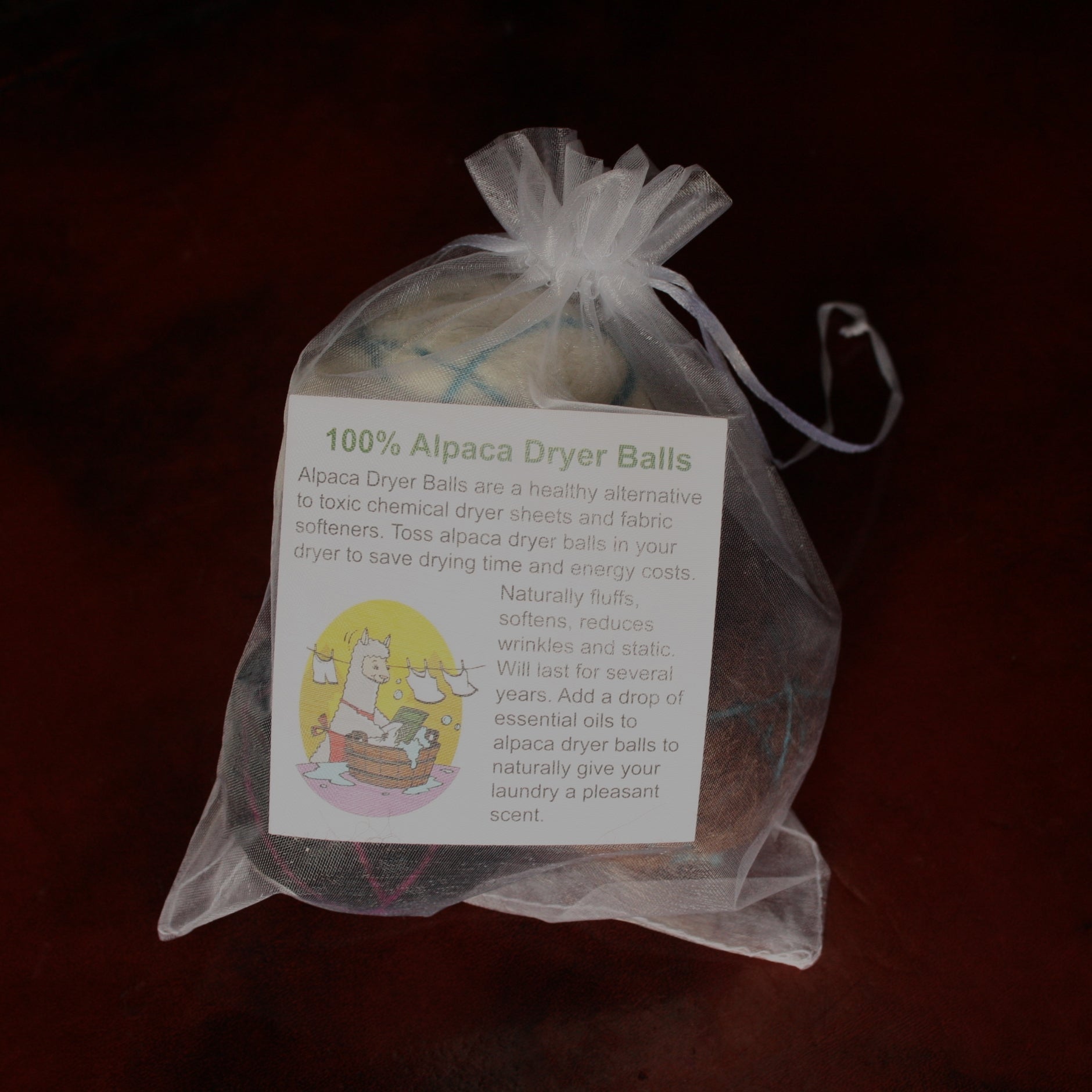 100% Alpaca Dryer Balls in a clear drawstring bag with a label on a dark background