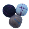 Three felted balls in black, gray, and blue with crosshatch patterns on a white background
