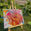 Colorful abstract painting on a small easel outdoors