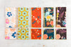Blue and floral cotton cloth napkins folded and stacked on a wooden board