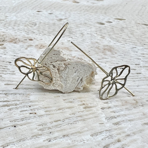 Butterfly-shaped earrings on a textured white surface