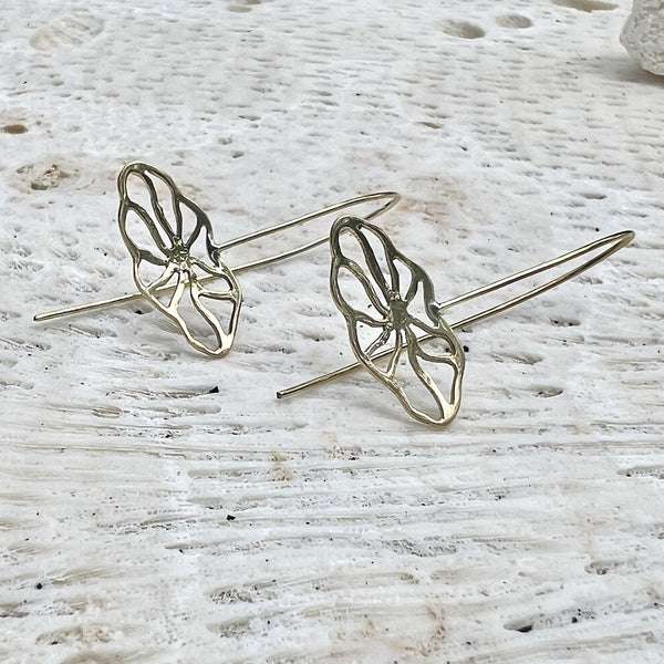 Butterfly-shaped earrings on a textured white surface