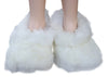 White fluffy slippers worn by a person on a white background
