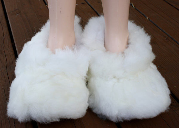 White fluffy slippers on a wooden floor