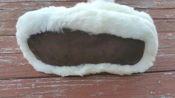 White fuzzy slippers on a wooden surface