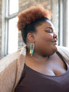 Model wearing geometric patina drop earrings — ethically made, nickel-free statement jewellery
