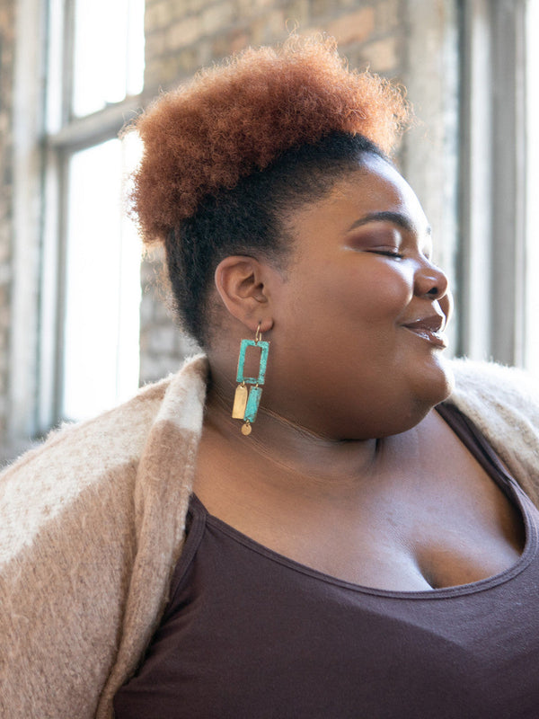 Model wearing geometric patina drop earrings — ethically made, nickel-free statement jewellery