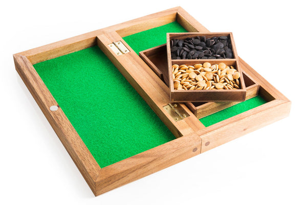 Wooden tray with compartments containing nuts and seeds on a white background