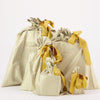 Set of yellow and white striped gift bags with ribbons on a white background