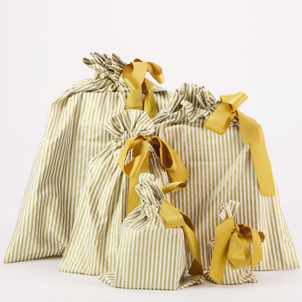 Set of yellow and white striped gift bags with ribbons on a white background